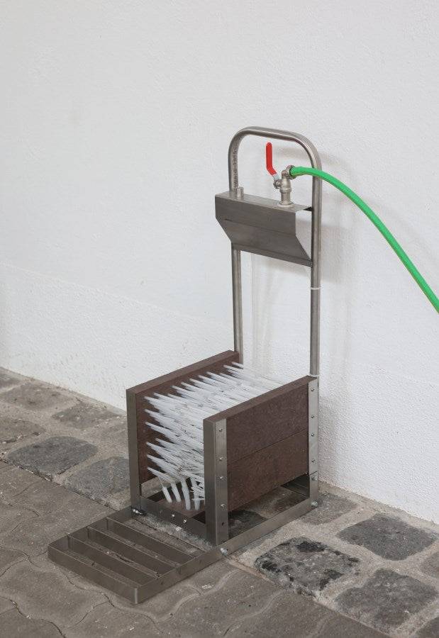 Stiefelreiniger robuste Edelstahlausführung mit angeschlossenem Wasserschlauch, perfekt für den Einsatz in der Betriebshygiene im Außenbereich.