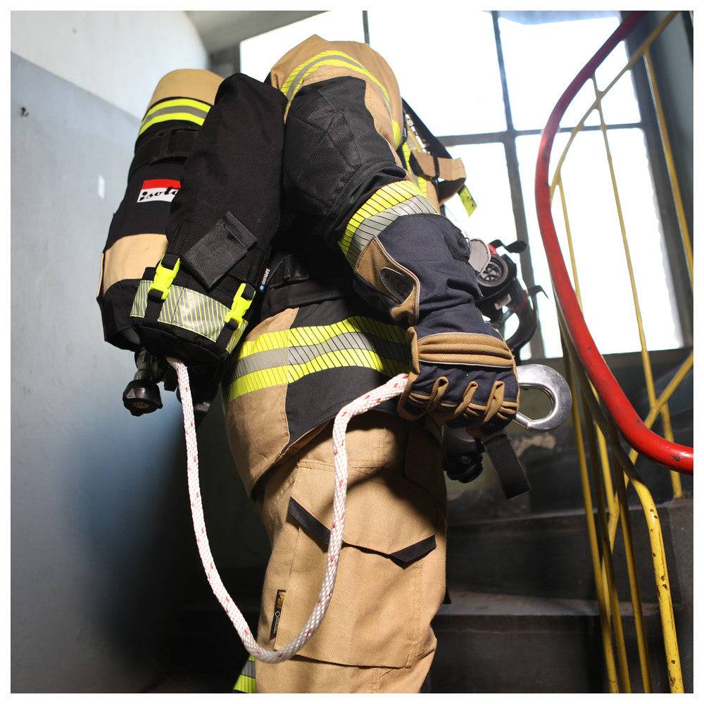Feuerwehrmann mit Leinenbeutel PA Atemschutzgerät auf Treppe, flexible Höhenanpassung und Notfallgriff für sichere Rettungseinsätze.