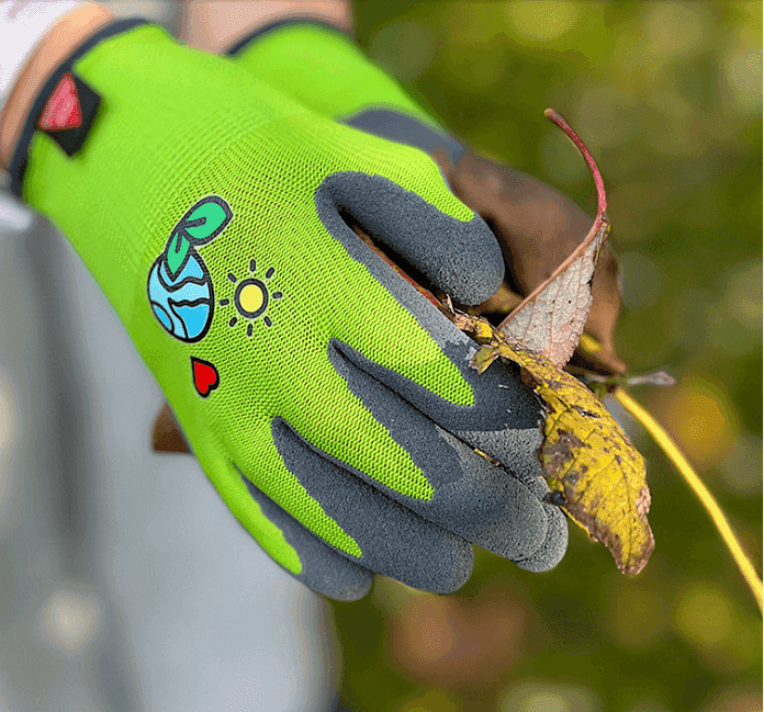 Grüner Kinderhandschuh Kids 3 Gr. 03 beim Einsatz im Garten, mit rutschfester Latexbeschichtung und kindgerechtem Motiv für sicheren Halt.