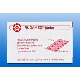 Verpackung des Kinderpflasters Rudamed Junior 10x6 cm mit Produktinformationen in Rot auf weißem Hintergrund. Ideal für die bunte Wundversorgung bei Kindern.