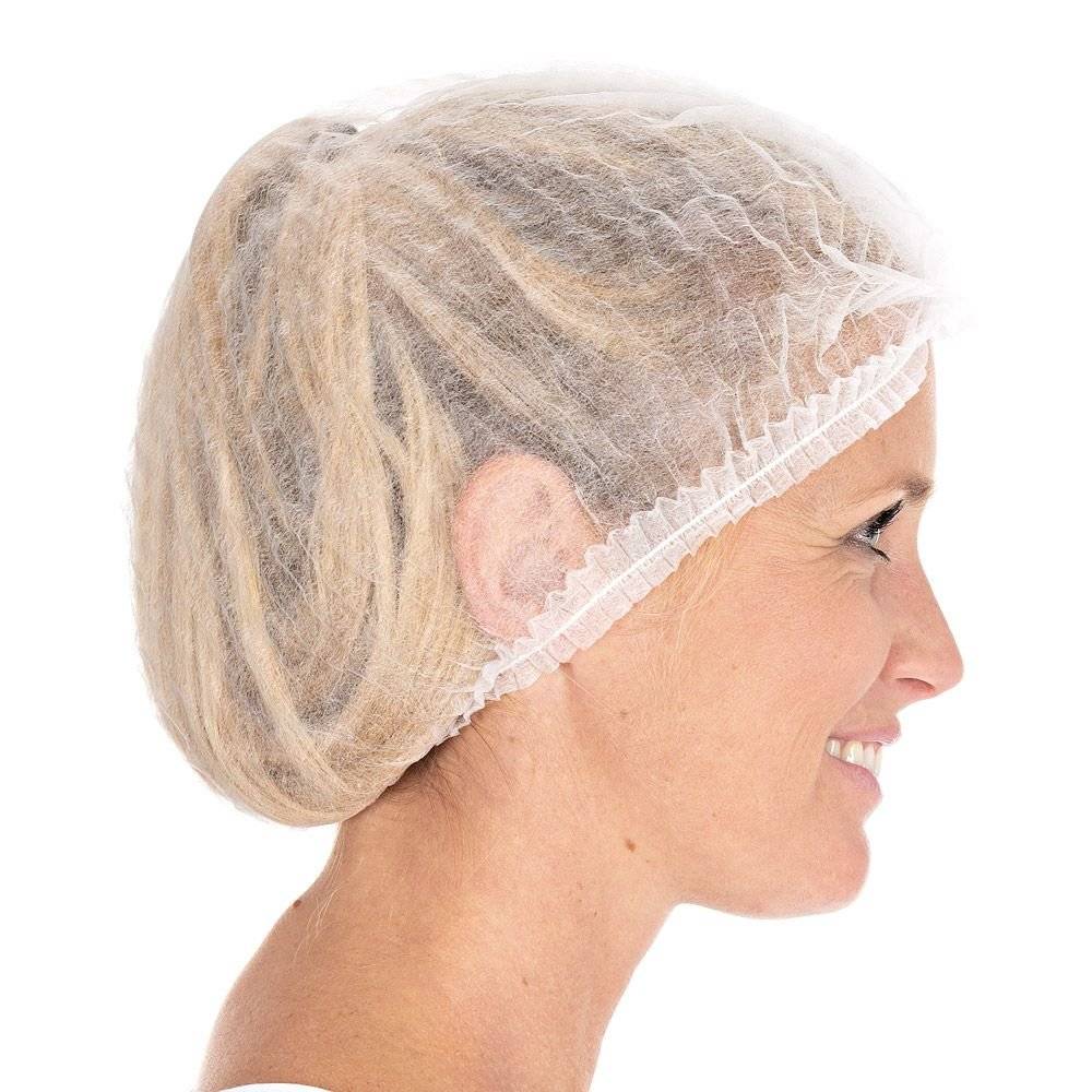 Frau mit blonden Dreadlocks trägt eine weiße Einweg-Haarnetzhaube aus Vliesstoff, seitliche Ansicht, geeignet für Hygiene- oder Lebensmittelbereiche.