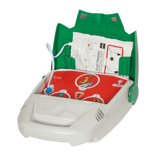 Das Bild zeigt einen geöffneten Defibrillator mit sichtbaren Elektroden und Anweisungen zur Anwendung. Das Gerät ist in Weiß mit roten und grünen Elementen gestaltet und enthält eine grafische Anleitung zur Platzierung der Elektroden.