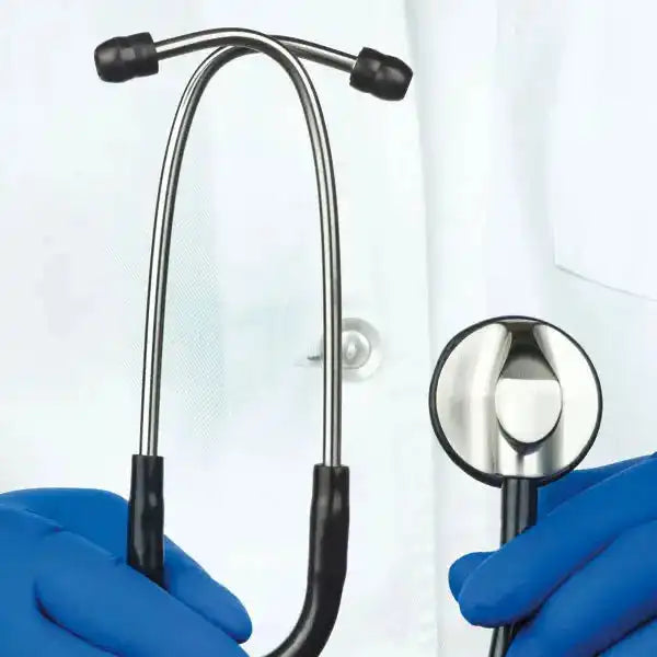 Medizinisches Stethoskop aus Edelstahl mit schwarzem Schlauch, in Gebrauch gehalten von einem Arzt mit blauen Handschuhen im Behandlungsraum