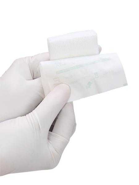 Sterile Gazin Mullkompresse 8-fach in Hand mit Handschuh für hygienische Wundversorgung im medizinischen Bereich.
