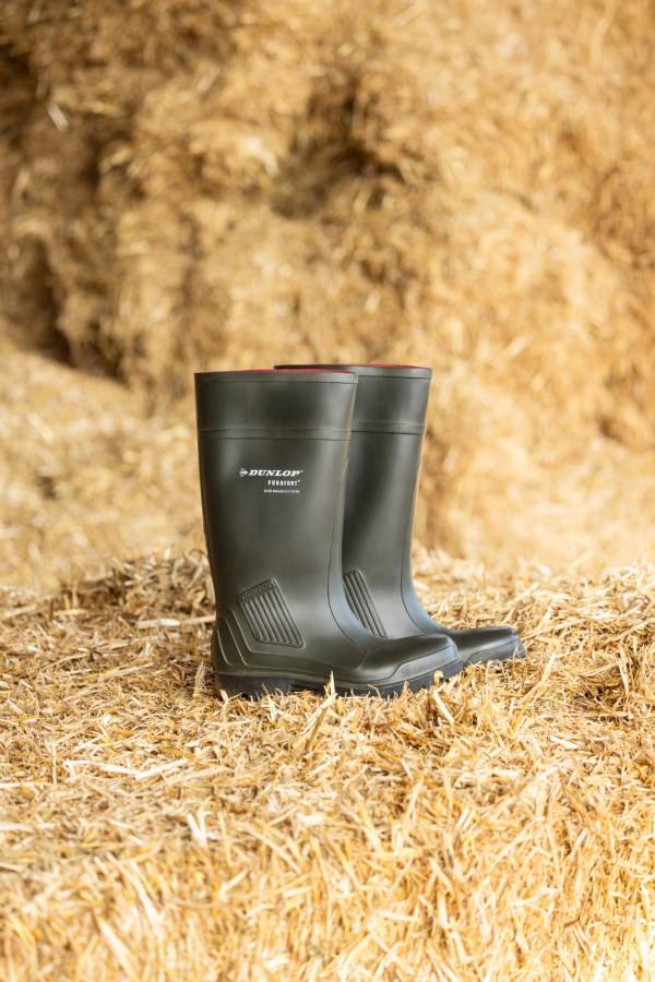 Sicherheitsstiefel Dunlop® Purofort® S5 in grün auf Stroh, mit Stahlkappe und Stahlzwischensohle, geeignet für Temperaturen bis -20 °C.